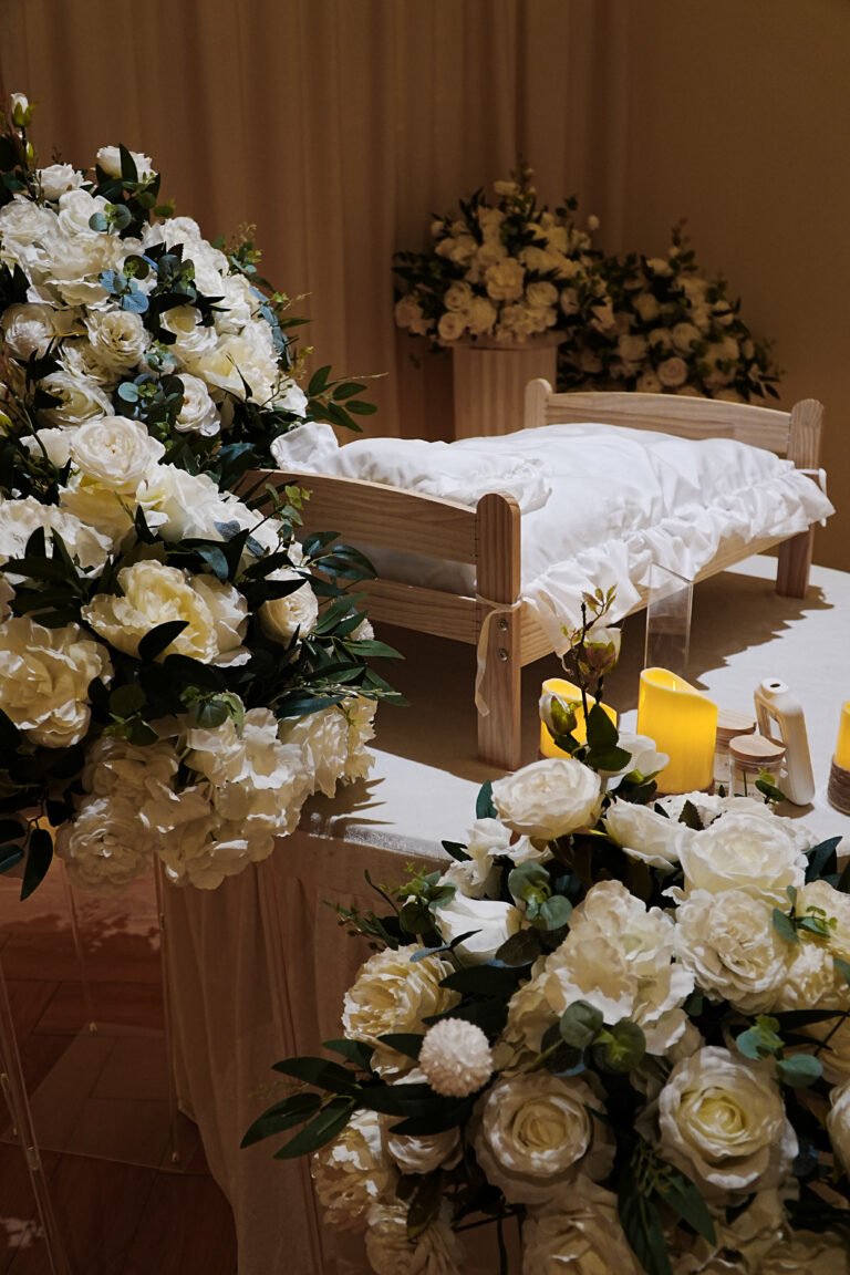 Pet memorial bed with white floral arrangement and candles at Furwell