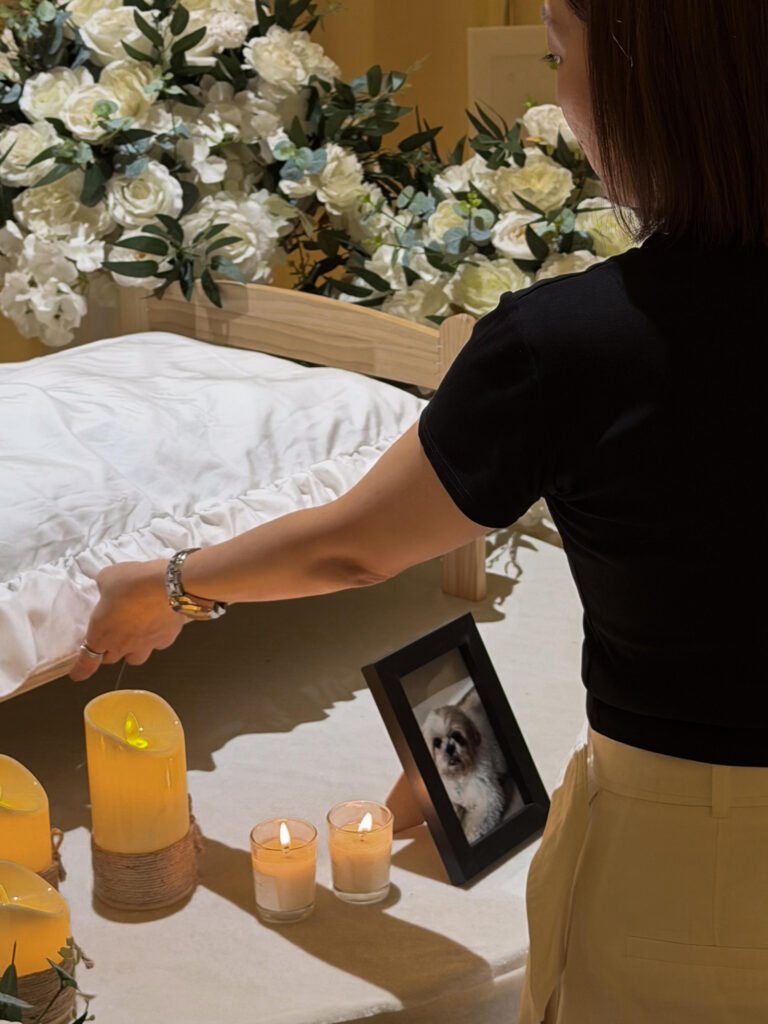 Furwell staff preparing a pet memorial bed with candles and flowers